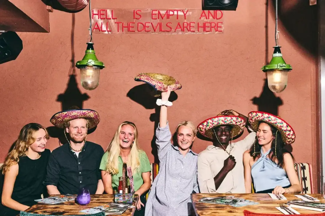 A group of friends in sombreros celebrating at Cartel's